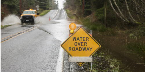 Flood sign in easl on side of flooded road