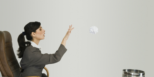 Woman throwing paper into a waste can